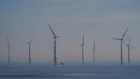 Several wind turbines in the blue sea, with a grey-blue sky