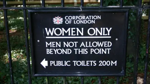 "Women only. Men not allowed beyond this point" in white letters against a black backdrop