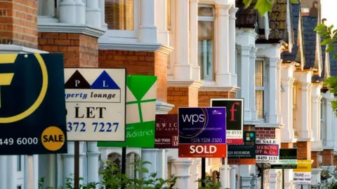 Getty images Row of houses with for sale signs outside