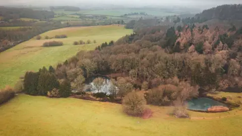 Greenshank Environmental Aerial image of a body of water surrounded by trees and fields