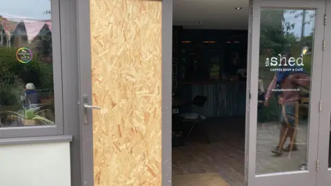The picture shows the front door of the cafe in Taunton boarded up.