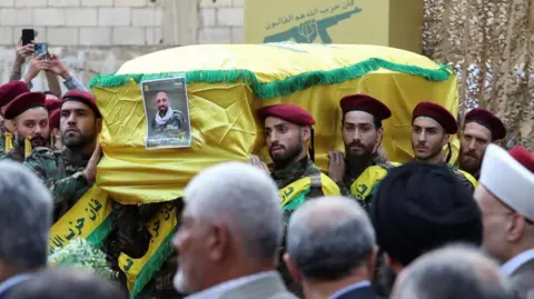 Reuters Men carry the coffin of a Hezbollah member who was killed in a pager blast (18/09/24)