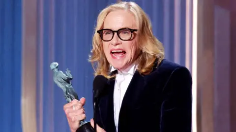 US actress Amy Madigan accepts the award for Outstanding Performance by a Female Actor in a Supporting Role in a Motion Picture for "Weapons" during the 32nd Annual Actor Awards at the Shrine Auditorium in Los Angeles on March 1, 2026. 