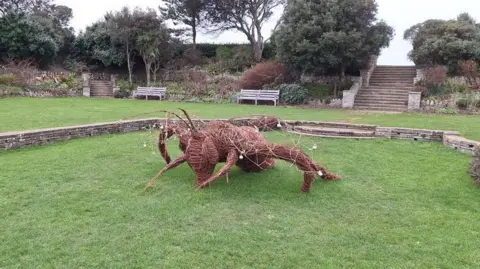 A giant bumble bee sculpture made out of willow weave in the sunken garden 