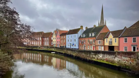 WALKINGTRACTOR/BBC WEATHER WATCHERS A row of colourful houses in Norwich by the River Wensum.