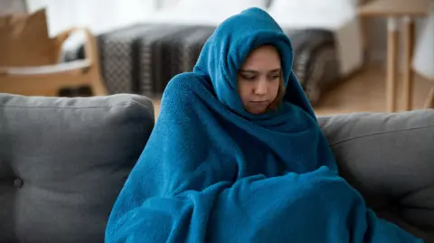 A woman wrapped in a blue blanket