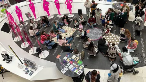 A drone shot of a group of mums with their babies at a special event held inside Liverpool's Central Library. 