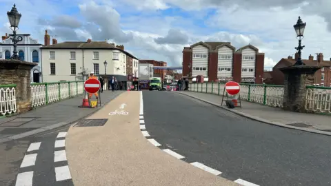 BBC The road heading across the bridge to Eastover, East Quay and Salmon Parade, with a red no-entry signs flanking the road.