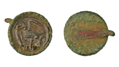 Suffolk County Council Back and front of a Tudor-era hat badge, with a hawk on the front and the remains of a clip on the back