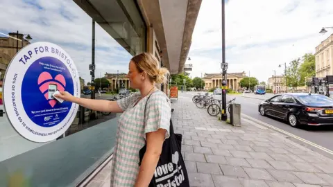 Bristol City Centre BID A women tapping a donate area