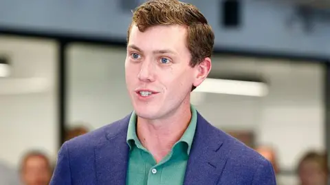 Getty Images Flock founder and chief executive Garrett Langley wearing a blue suit jacket and green shirt