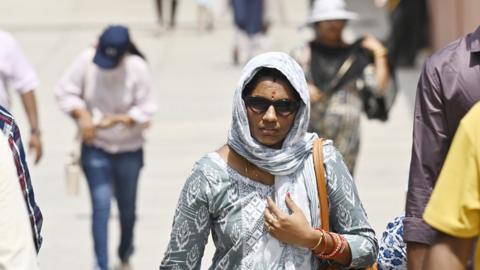 Visitors brave the heat Wave during a hot summer afternoon in New Delhi, India.