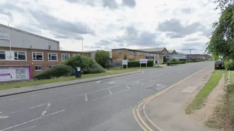 Google Image of a main road through an industrial business area. The road bears double yellow lines and block-style business premises