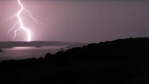 Colleen Webb Shows lightning to the left of the picture above water and land