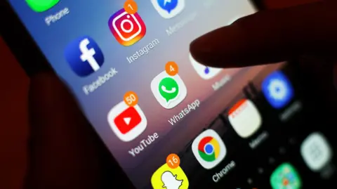 PA Media Picture of a smart phone with Facebook WhatApp Youtube and Snapchat icons showing 