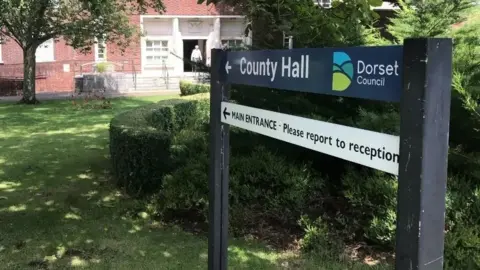 BBC An image of a sign, which shows the directions to Dorset Council's county hall