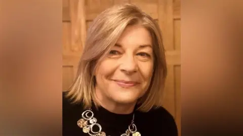 Contributed Rachel MacSweeney smiles at the camera. She has short blonde hair and wears a black top with a necklace on. 