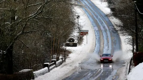 Reuters A car driving along a snowy road in Leek, Staffordshire