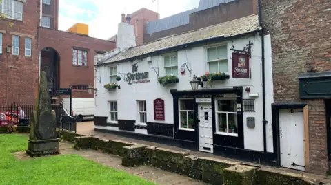 A wide photograph of the Sportsman Inn in Carlisle