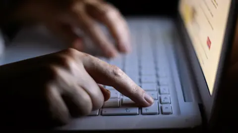 PA Someone's hand on a laptop keyboard