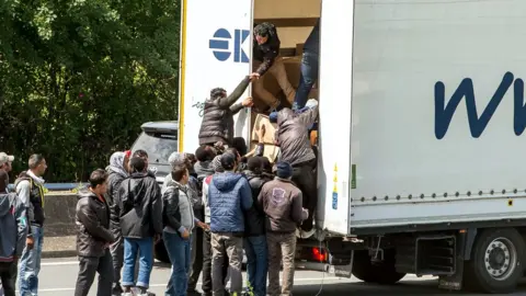 AFP/Getty Images Migrants getting onto a truck heading for the Eurotunnel