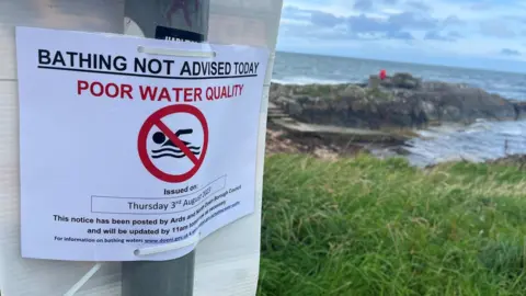 BBC Sign reading 'bathing not advised today - poor water quality'