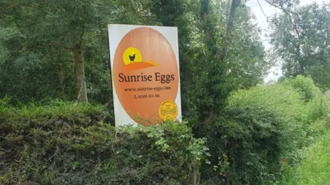 Sign for Sunrise Eggs with bushes in the background