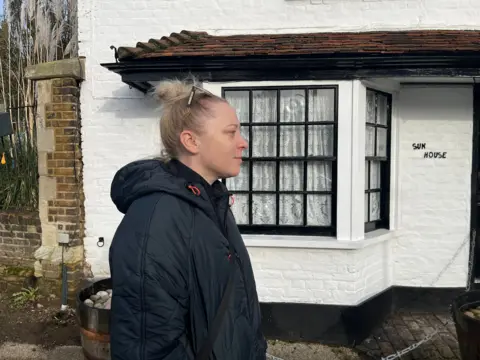 Side-on view of Emily in front of Sun House