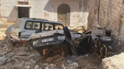 Cars on their side and on their roof in Derna