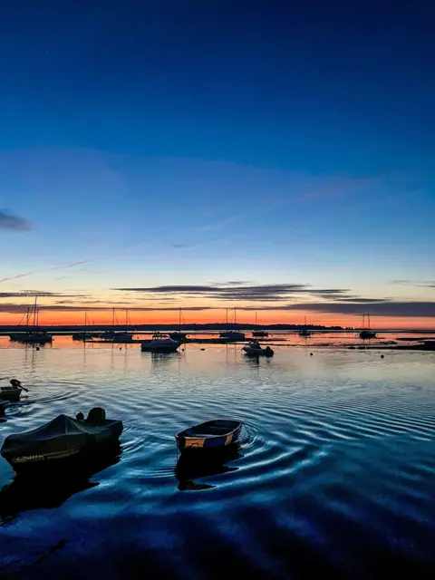 Fiona MacCallum Ripples in a lake around a boat