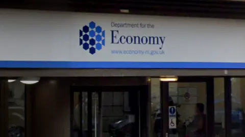 A sign of the Department for the Economy which is white and blue. 