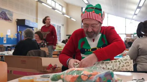 Stephen Huntley/BBC Volunteer wrapping presents