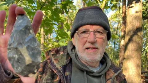 Geologist Richard Myerscough holds a flint axe left by the people of Doggerland. 