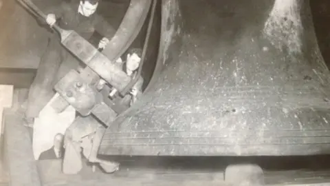 Family handout Ron Witty striking a bell manually with colleague William (Bill) Wrighton