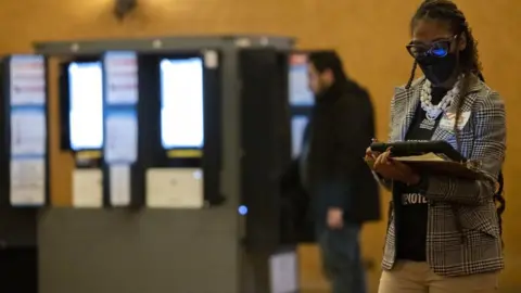 Getty Images Election workers in Atlanta, Georgia, on 6 December 2022