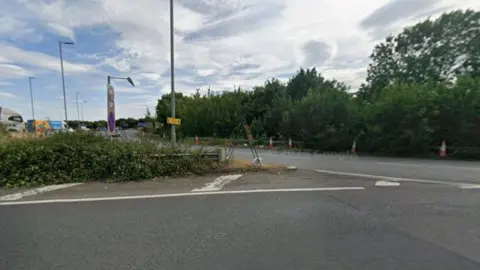 Part of a main road shows traffic approaching a roundabout
