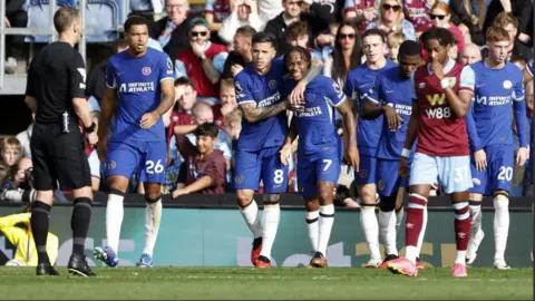 Chelsea players Raheem Sterling and Enzo Fernandez hug as they celebrate a Burnley own goal at Turf Moor