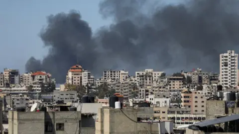 Reuters Smoke rises from Gaza City as Israeli forces continue an operation at al-Shifa hospital for a third day (20 March 2024)
