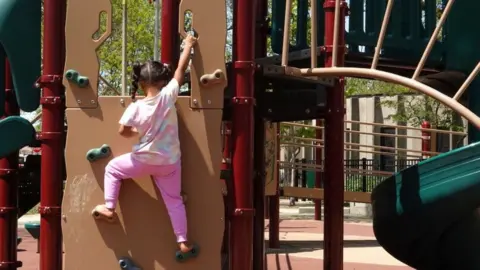 Getty Images A migrant girl who arrived with her family from Venezuela plays in a Chicago playground