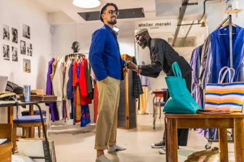 Andrew Esiebo Amah styling a client in a vintage blue worker jacket