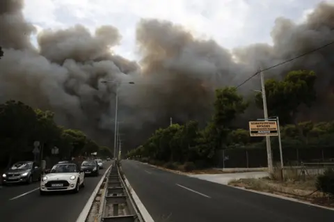EPA Smoke rises over a motorway in Neo Voutsa, a northeast suburb of Athens