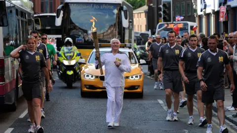 Ben Birchall/PA Stan Wild with Olympic torch in 2012