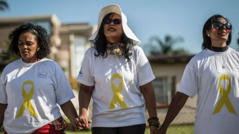 Getty Images Community members gather for a prayer in Soweto, Johannesburg