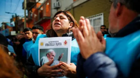 Reuters A person holds a picture of Pope Francis as faithful attend a mass to rebuff attacks on Pope Francis by presidential candidate Javier Milei, of La Libertad Avanza coalition, in the villa 21-24 neighbourhood, in Buenos Aires, Argentina, September 5, 2023.