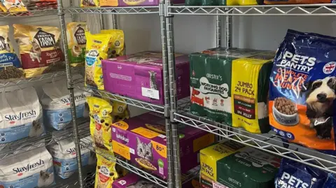 Tyesha Muncaster An image of various pet food on wire shelves 