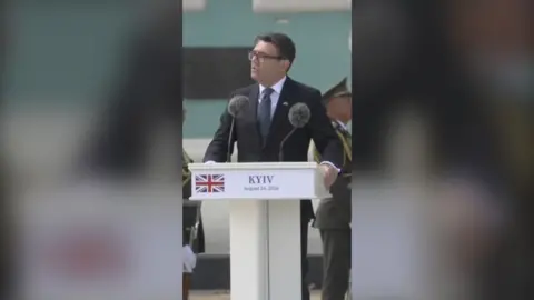 Prime Minister Andy Burnham standing at podium 