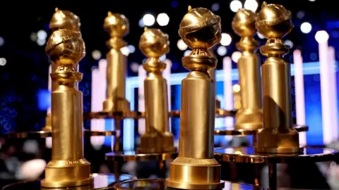 Emma McIntyre Golden Globe trophies