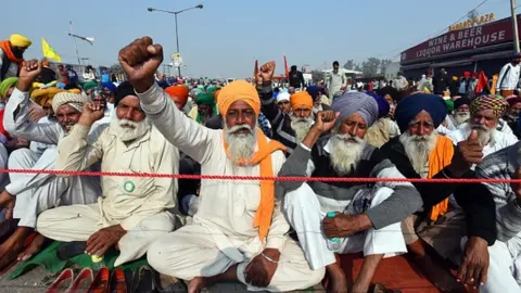 Getty Images Farmers raise slogans during a protest over farm reform laws at Singhu border on 2 December 2020 in New Delhi