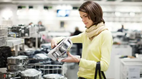 Getty Images Woman shopping for kitchen pans