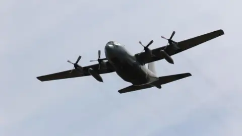 Dark-coloured military aircraft in the sky